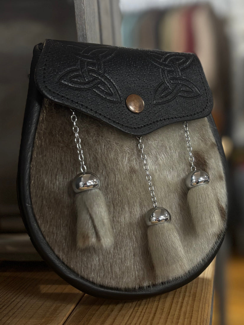 Traditional Scottish sporran on a wooden surface with a blurred background