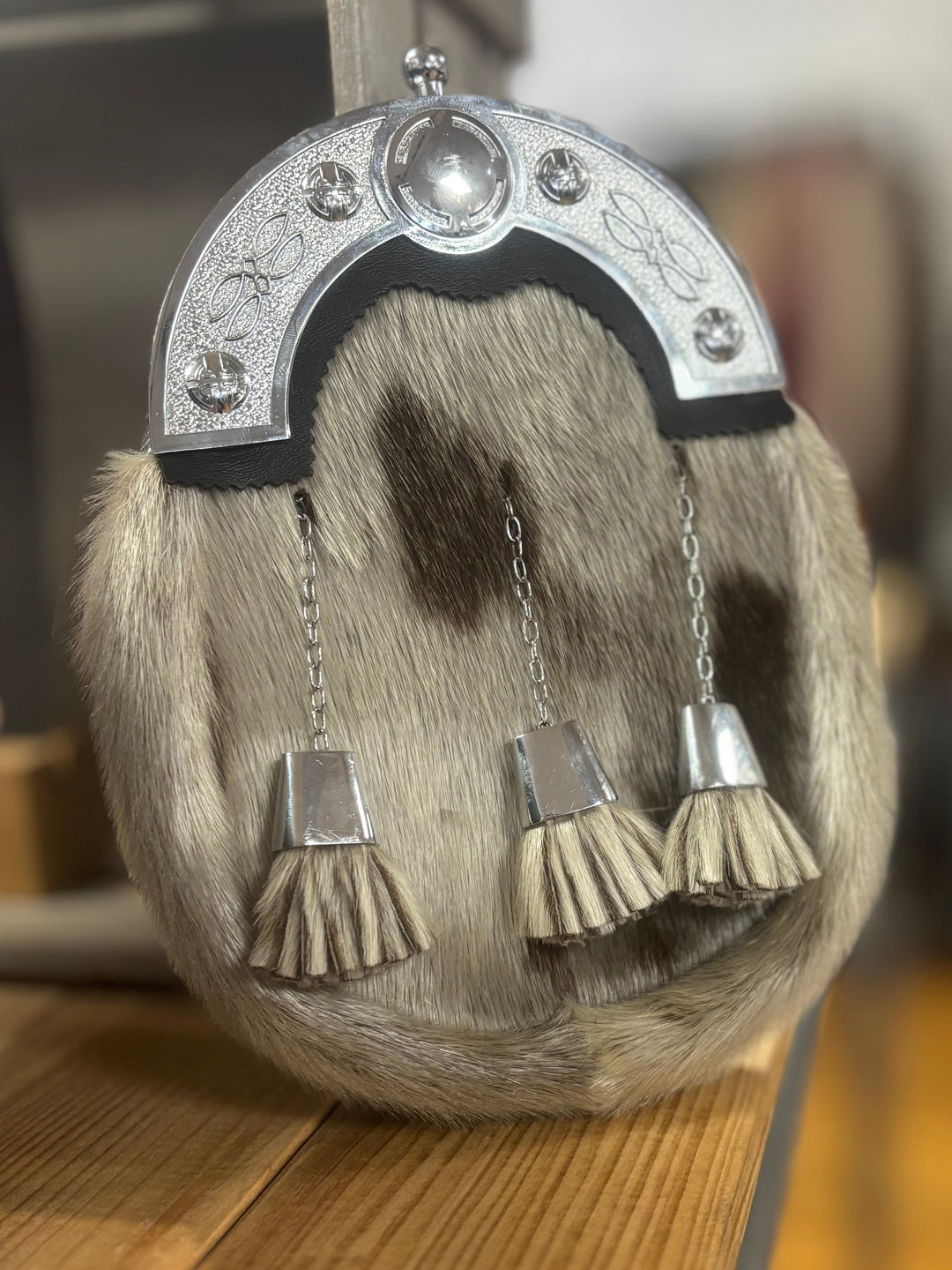 Scottish sporran with tassels on a wooden surface